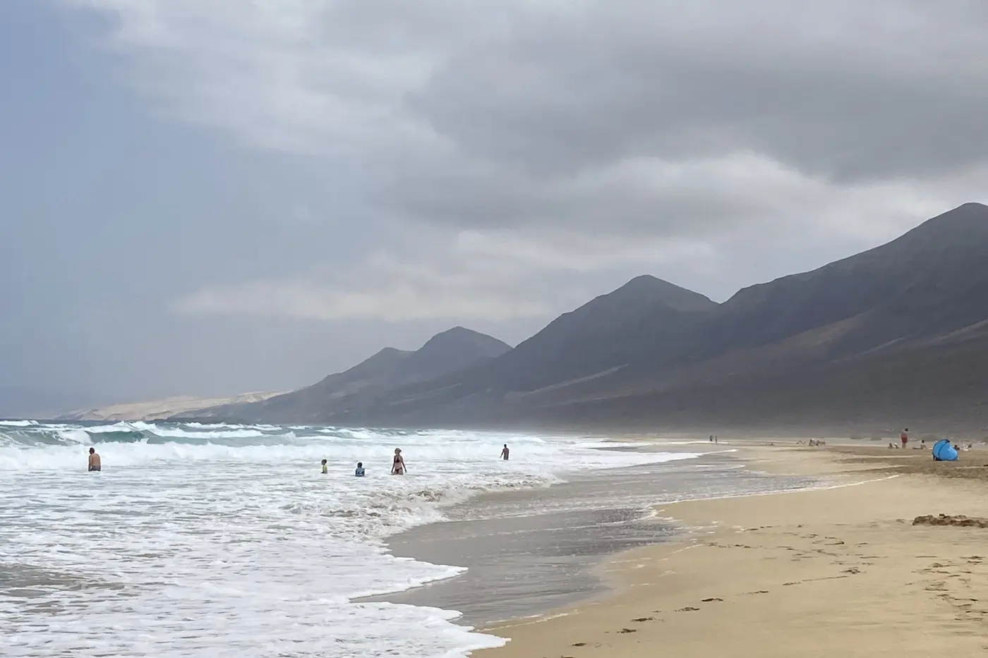 Bathers in the waves at Cofete, at the foot of the Jandía massif