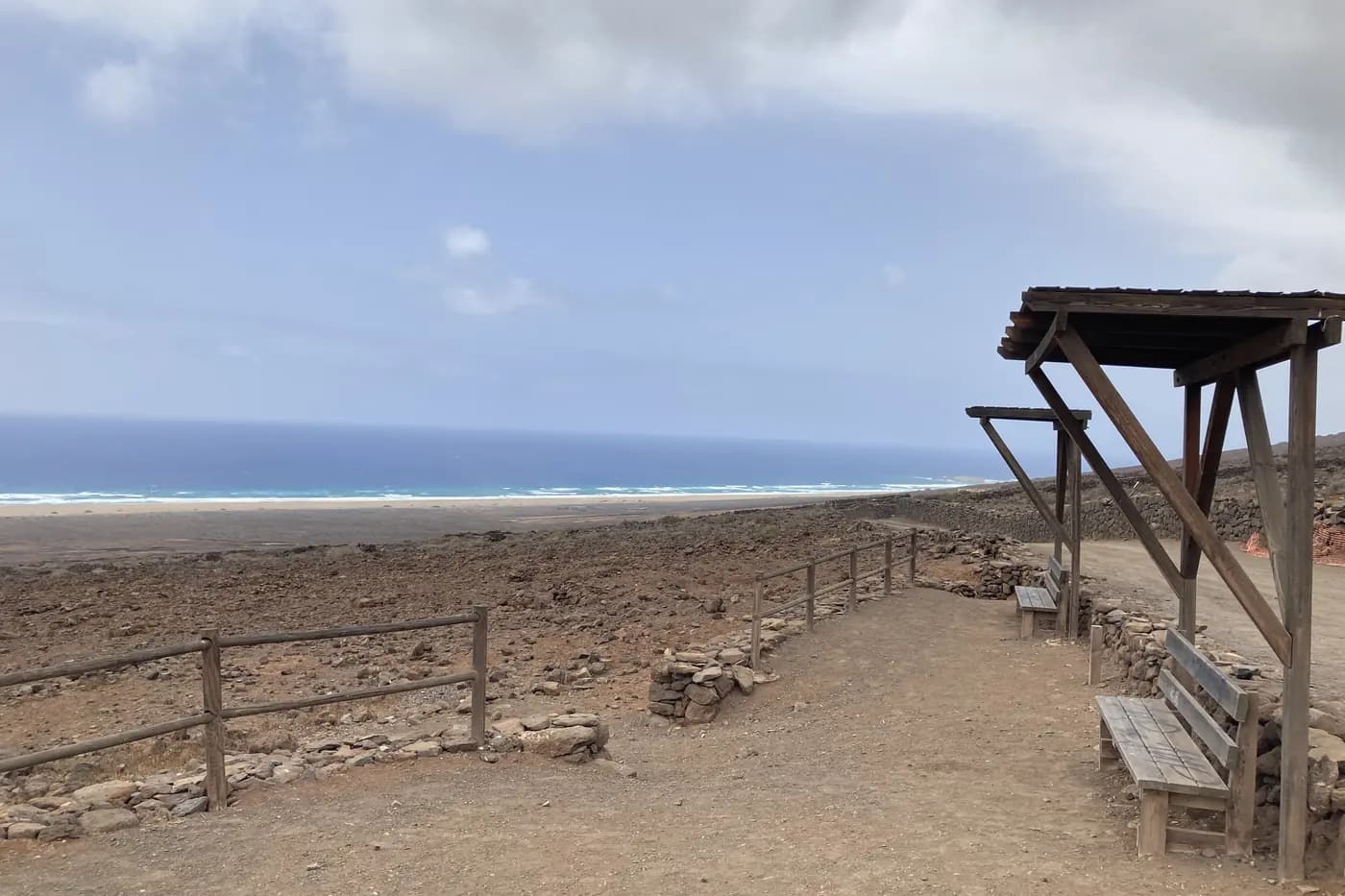 Benches at a viewpoint on the Cofete track, with the ocean below