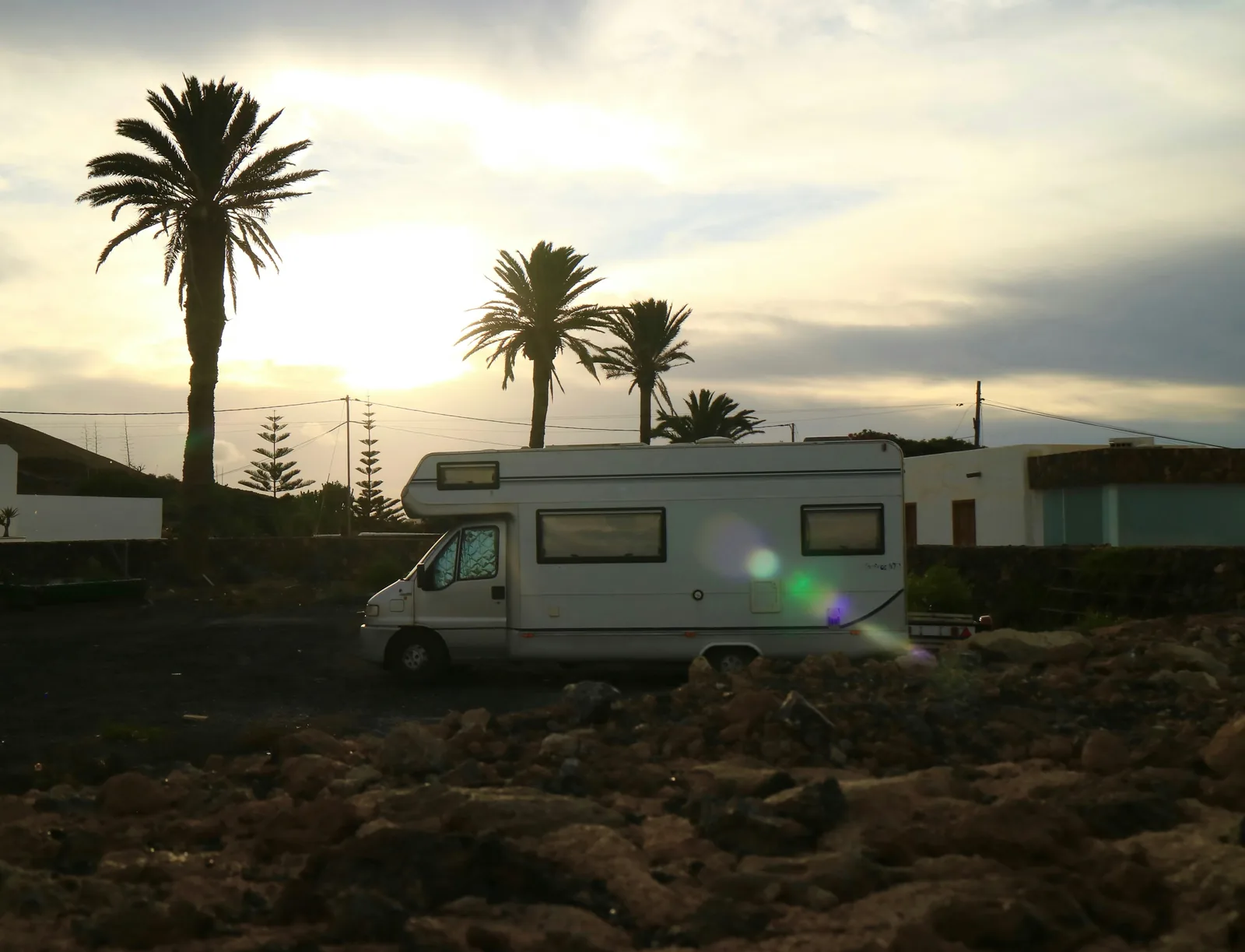 Camping-car garé au coucher du soleil parmi les palmiers à Lanzarote