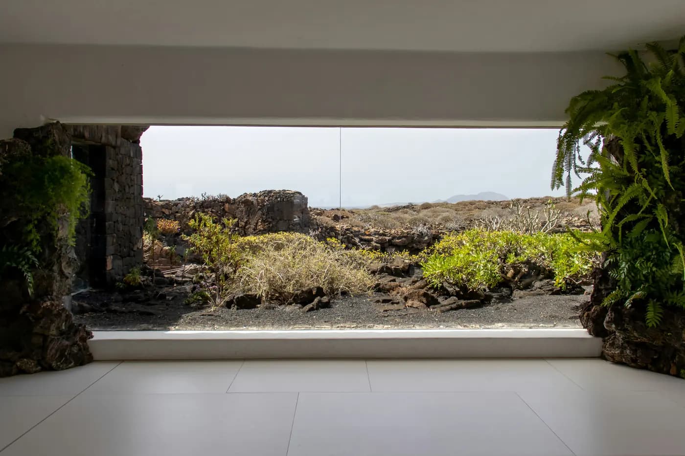Glass-walled room at Jameos del Agua opening onto Lanzarote's volcanic landscape