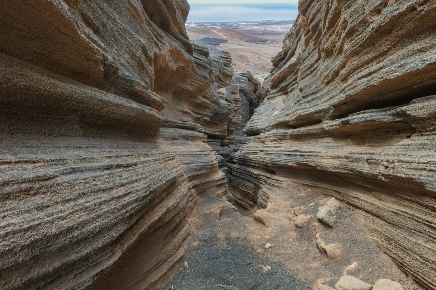 One of the volcanic fissures of Las Grietas in Lanzarote, with the ocean in the background