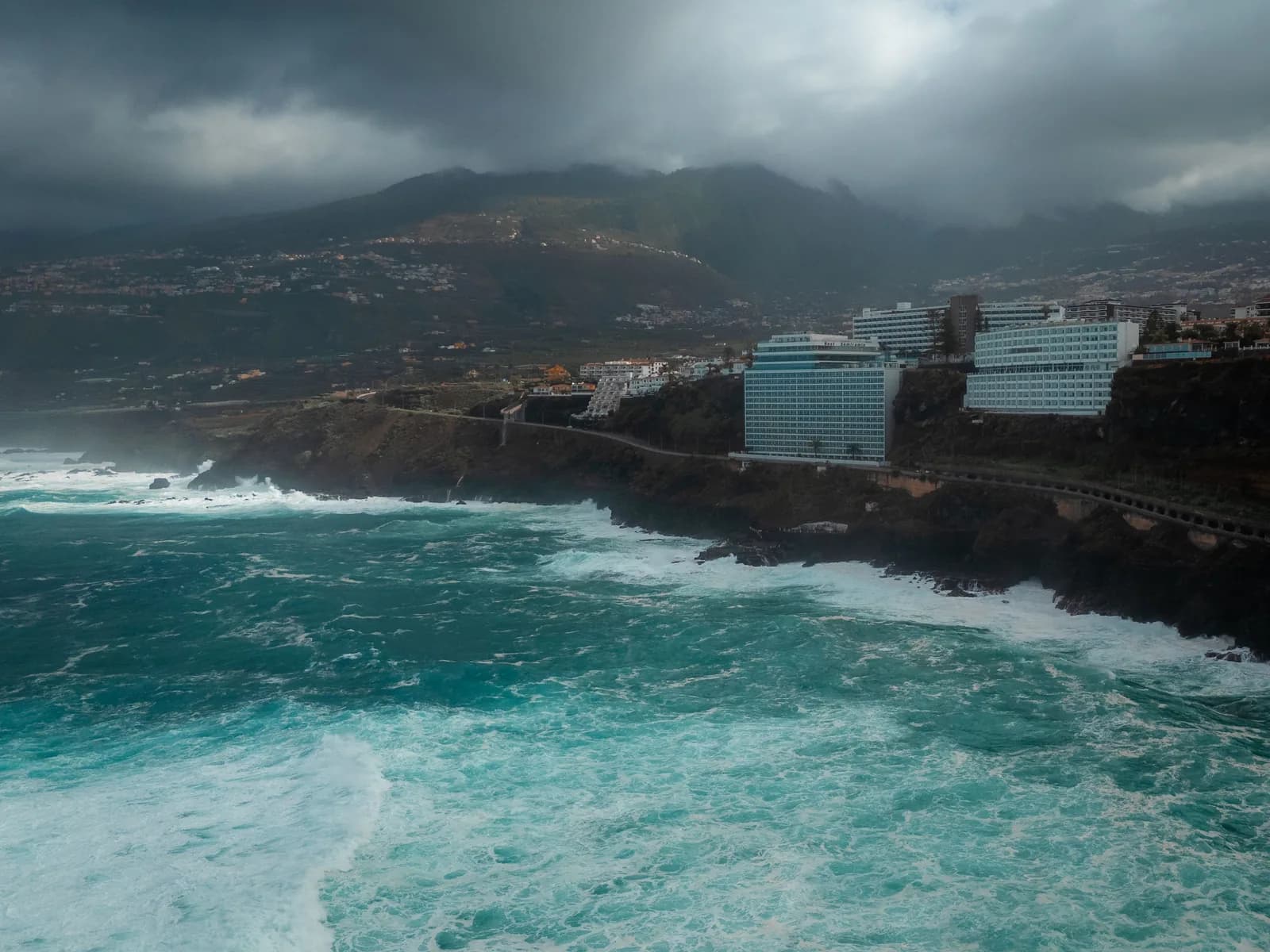 Mer agitée et ciel orageux sur la côte nord de Tenerife, hôtels au bord des falaises