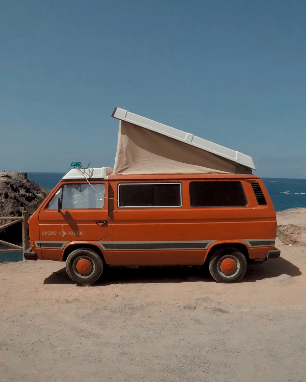 Vintage-Campingbus in Orange, am Meer auf Teneriffa geparkt