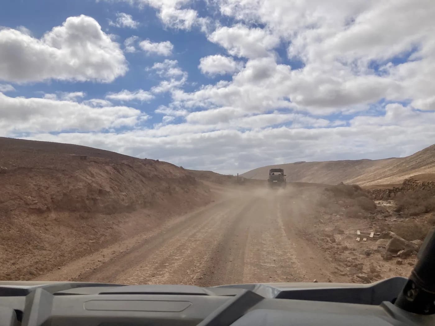 A convoy of buggies kicking up dust on a track in Fuerteventura's interior