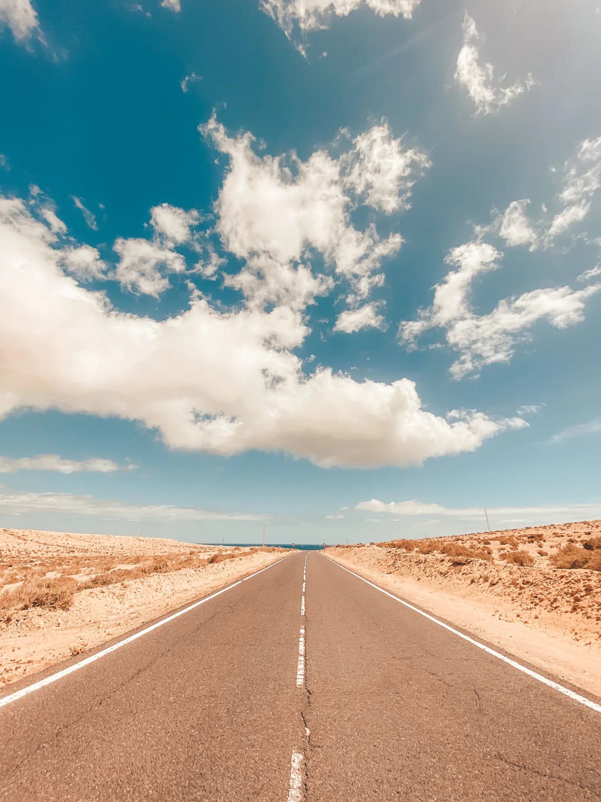 Menschenleere, gerade Straße auf Fuerteventura Richtung Meer, ideal für einen Campervan-Roadtrip